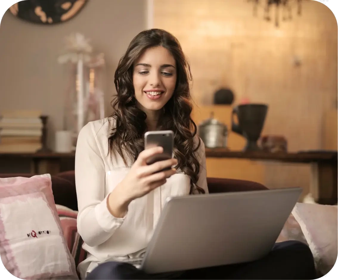 Woman using phone and laptop
